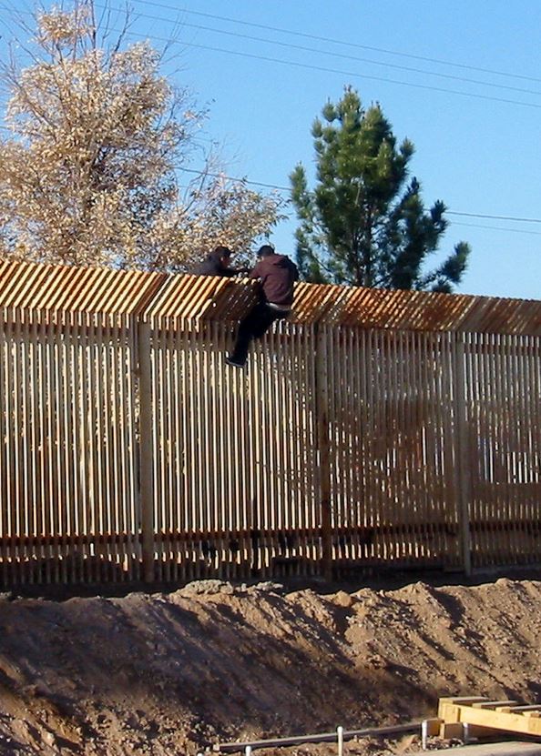 Two men scale the border fence into Mexico near Douglas, Arizona, 2009