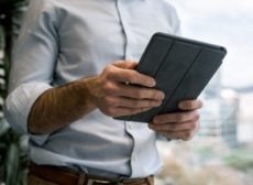 man reading a tablet, probably the IFSEC Global newsletter